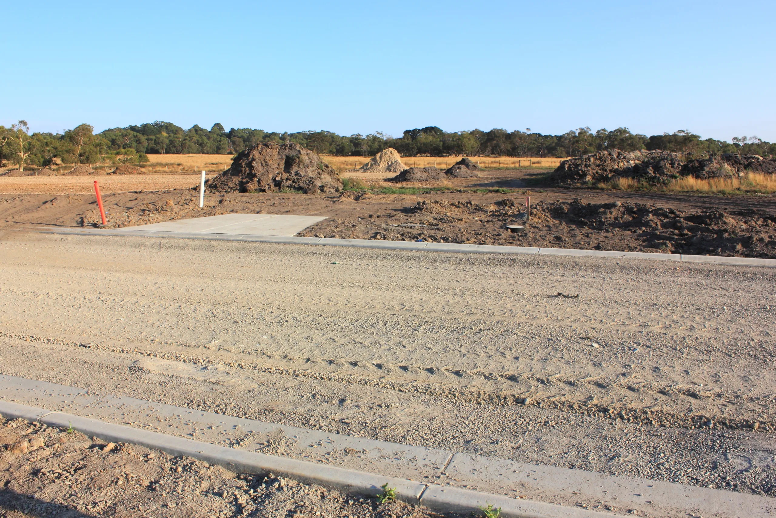 Excavator loading soil into a dump truck at a construction site.